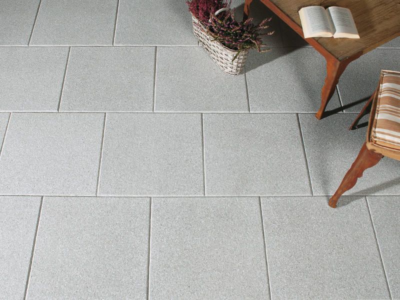 Ein weißer Fliesenboden mit einem Stuhl und einem Buch darauf