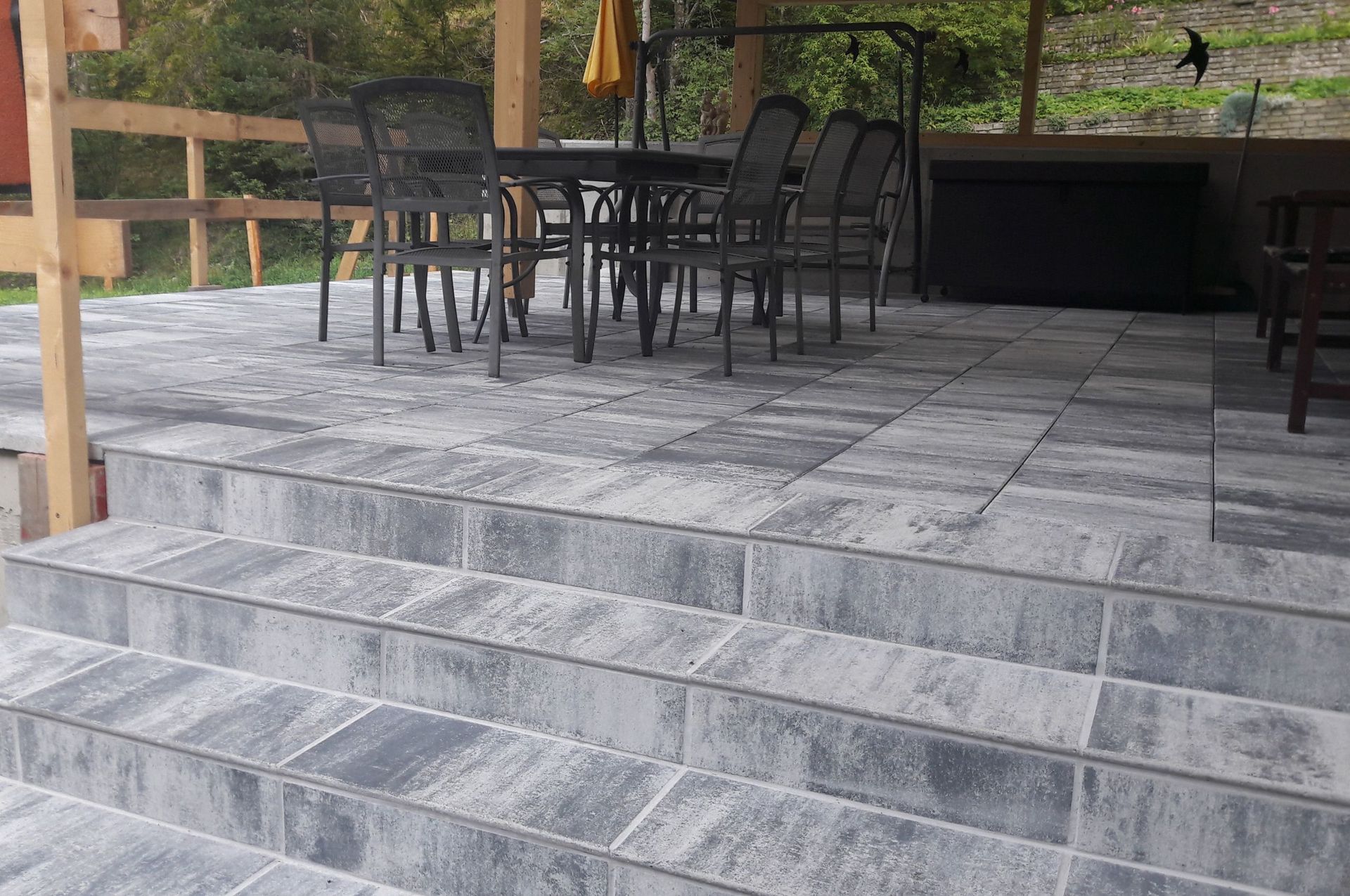 Eine Terrasse mit einem Tisch und Stühlen und einer Treppe, die dorthin führt.