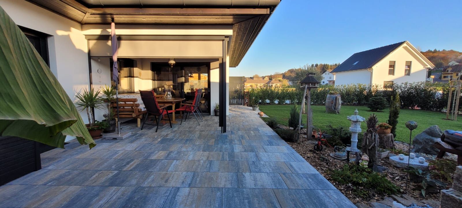 Eine Terrasse mit Tisch und Stühlen vor einem Haus.
