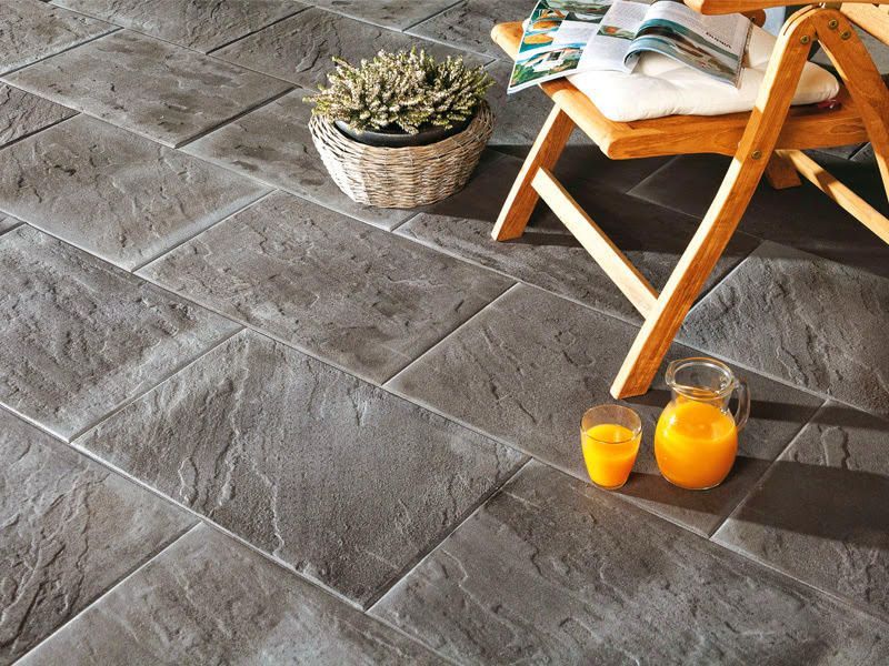 Zwei Gläser Orangensaft stehen auf einem gefliesten Boden neben einem Stuhl