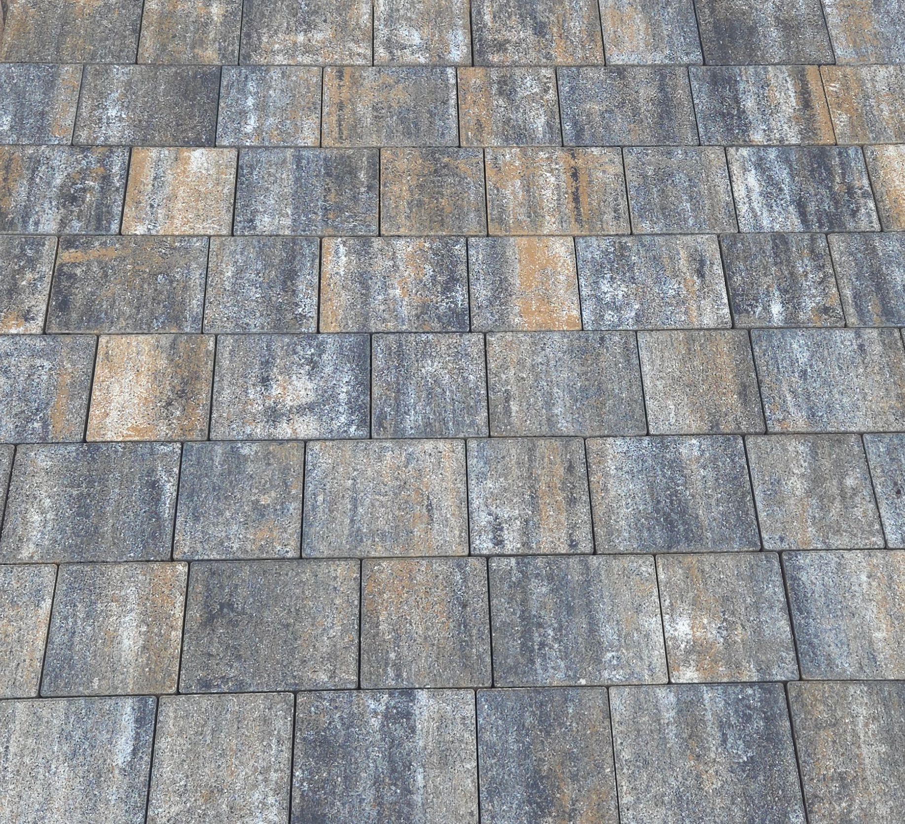 Nahaufnahme einer gepflasterten Fläche aus rechteckigen Steinen aus Granitstein.