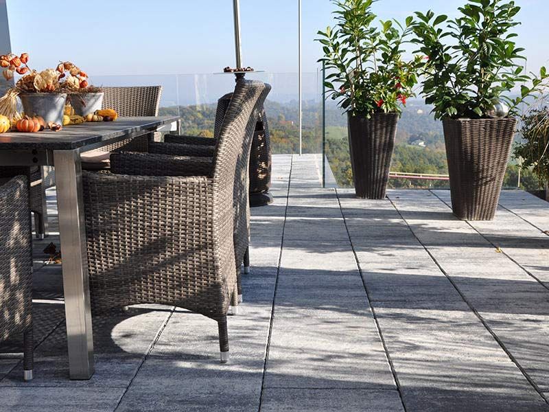 Eine Terrasse mit Tisch und Stühlen und Topfpflanzen