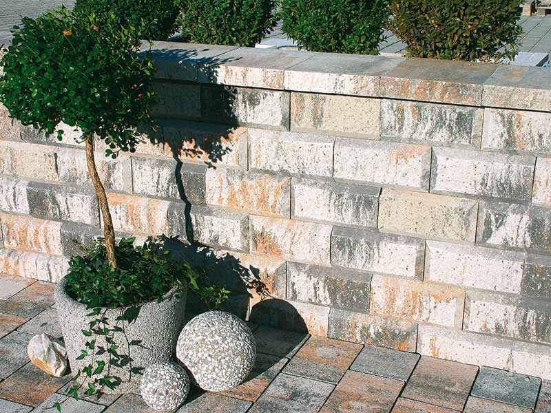 Eine Ziegelmauer mit einer Topfpflanze davor