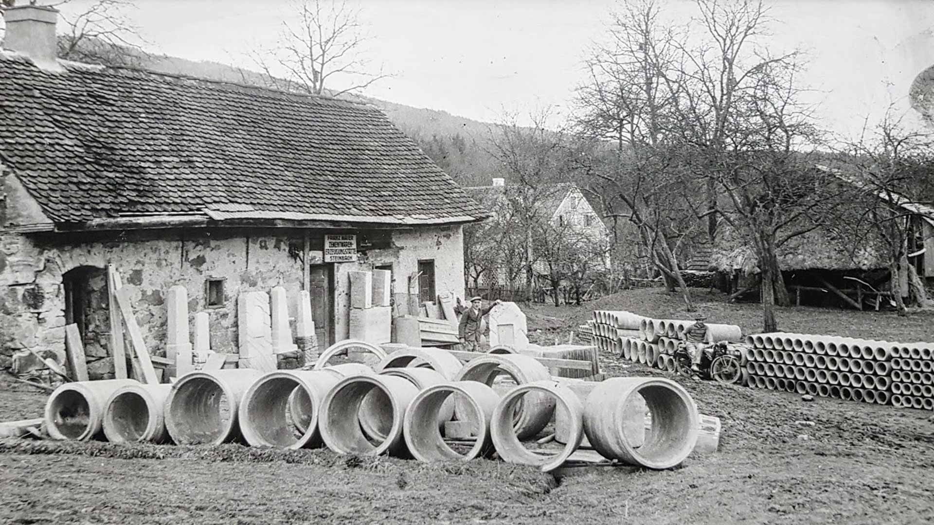 Ein Schwarzweißfoto einer Reihe von Rohren vor einem Haus.