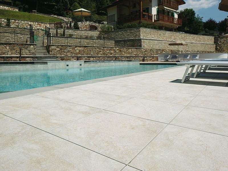 Ein großer Swimmingpool, umgeben von Stühlen und einer Steinmauer