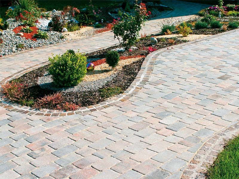 Ein gemauerter Gehweg, der zu einem üppigen grünen Garten führt