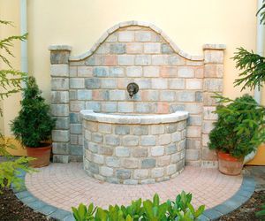 Eine Backsteinmauer mit einem Brunnen in der Mitte