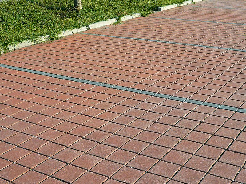 Ein gemauerter Gehweg mit einer blauen Linie an der Seite