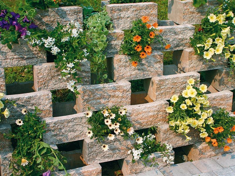 Eine Steinmauer, aus der Blumen wachsen