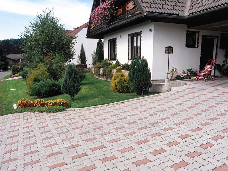 Ein weißes Haus mit einer gemauerten Auffahrt davor