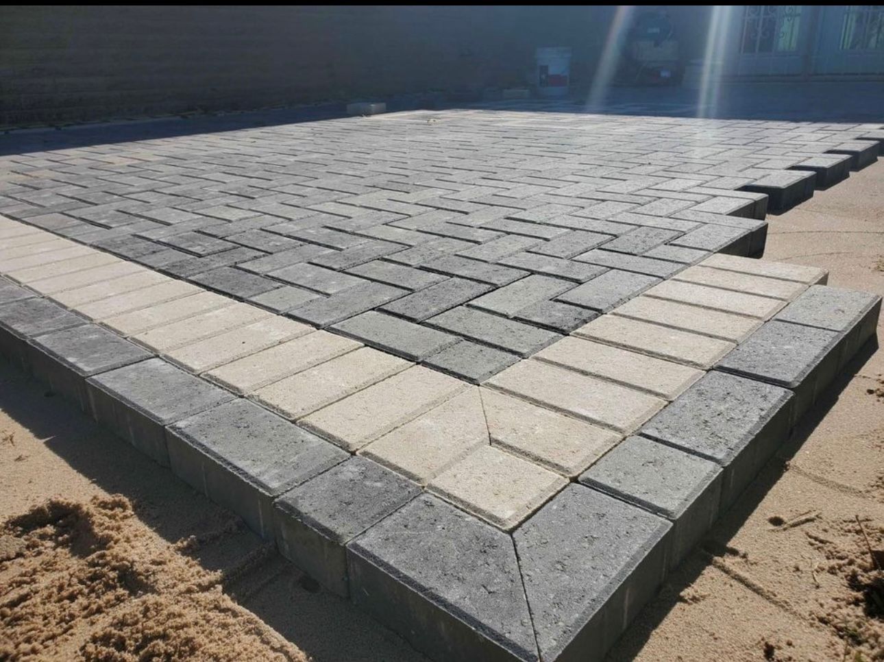 A row of bricks are sitting on top of a sandy surface.