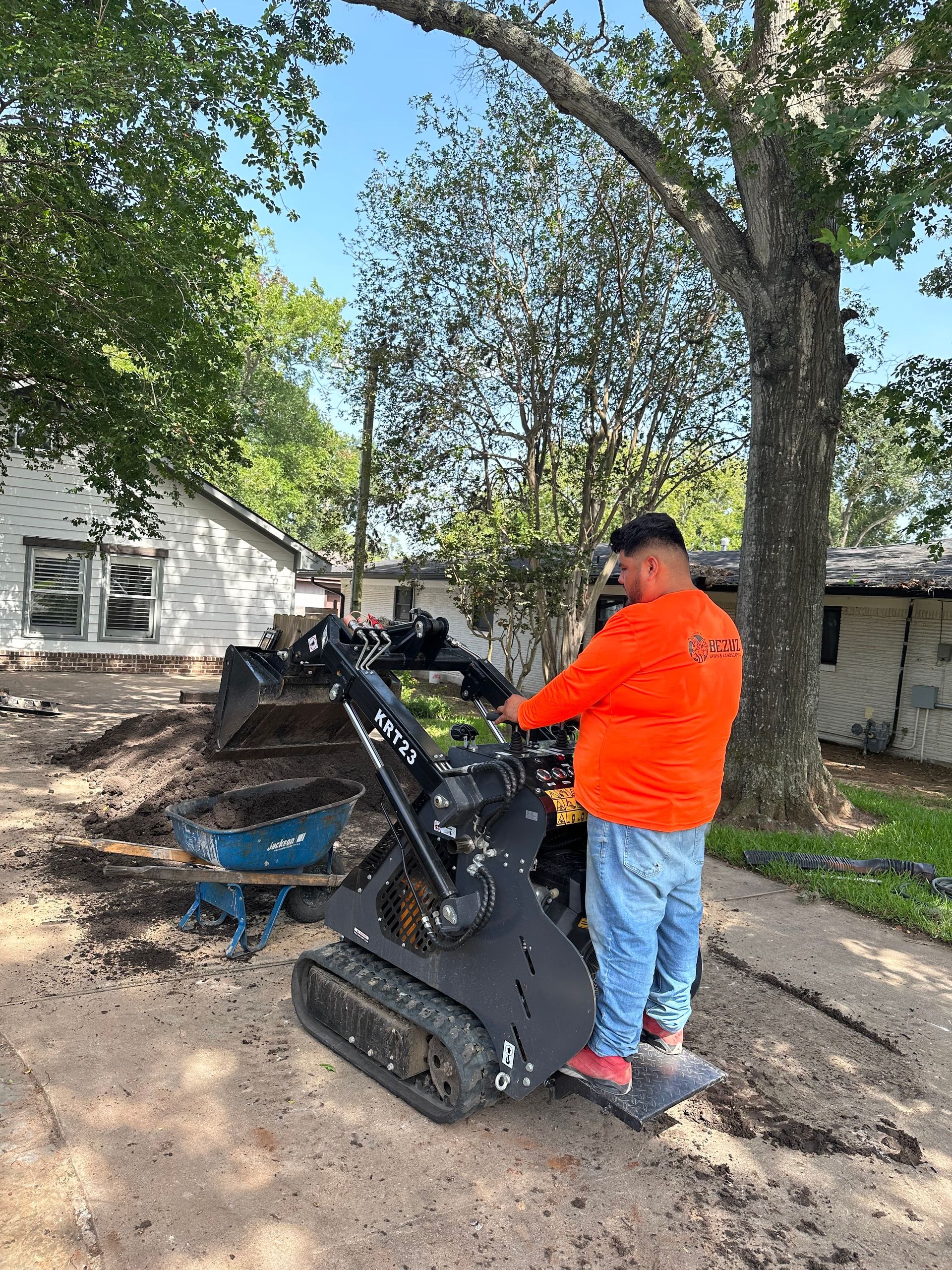 A man is standing next to a small tractor.