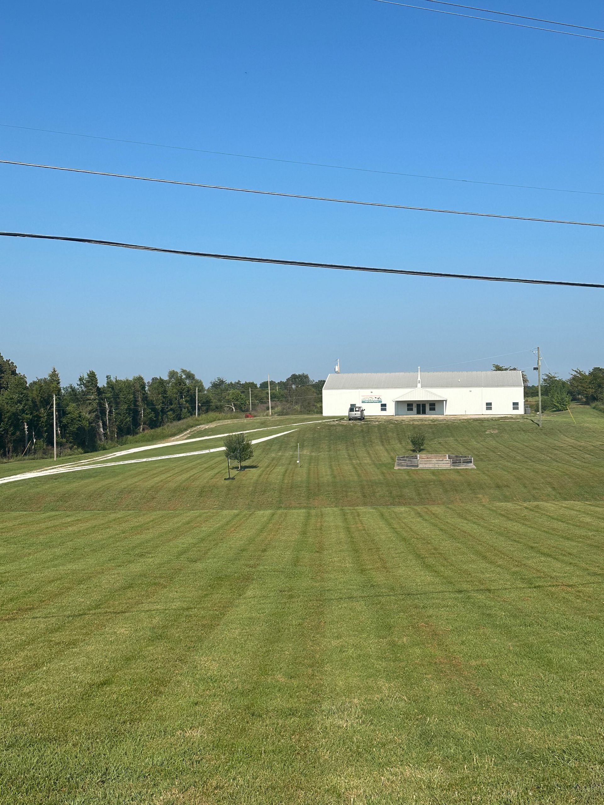 A large grassy field with a house in the background