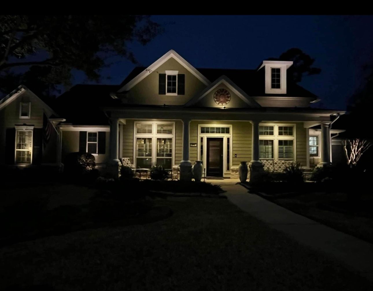 The front of a house is lit up at night