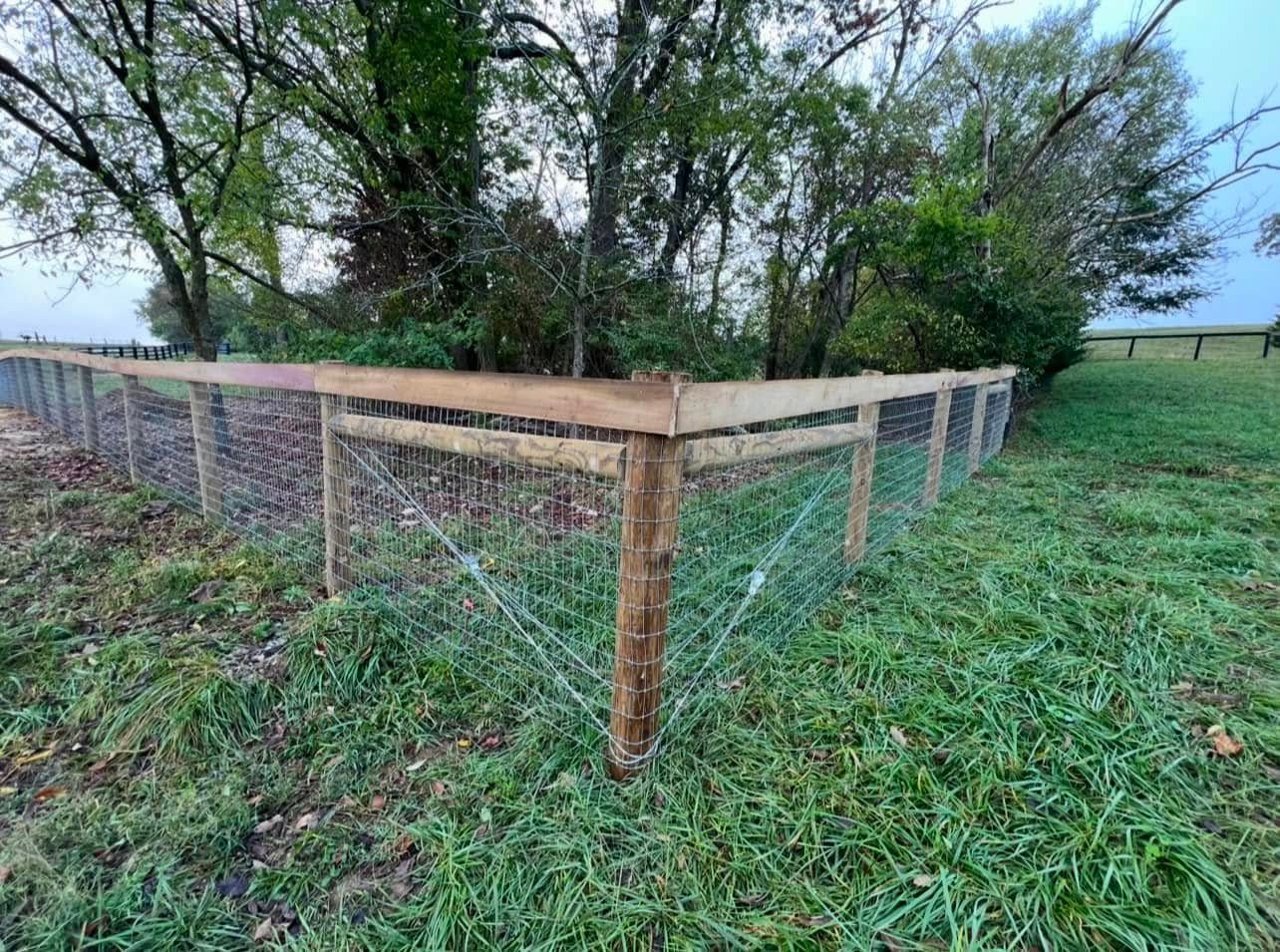 A wooden fence is sitting in the middle of a grassy field.