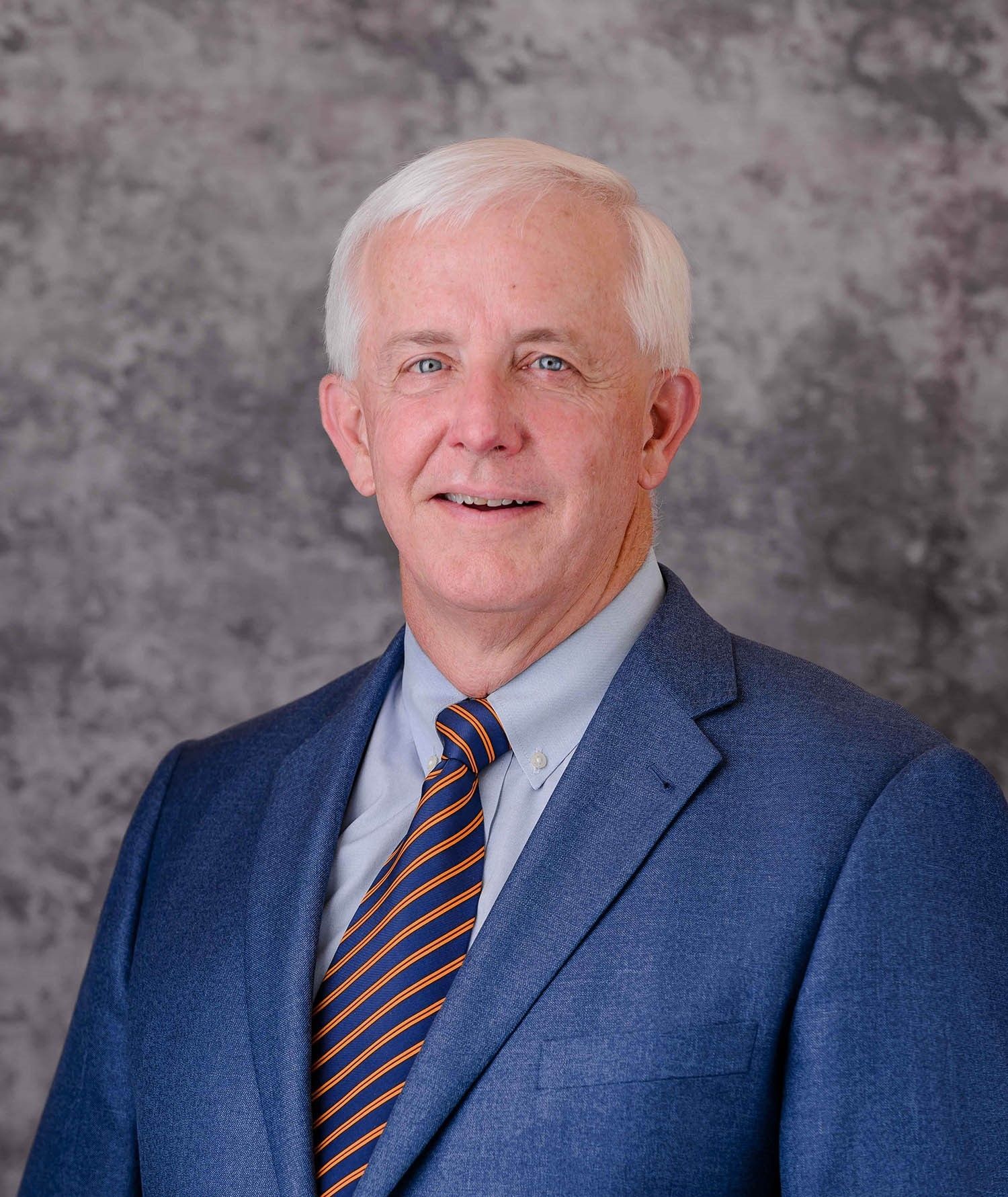A man in a suit and tie is smiling for the camera.