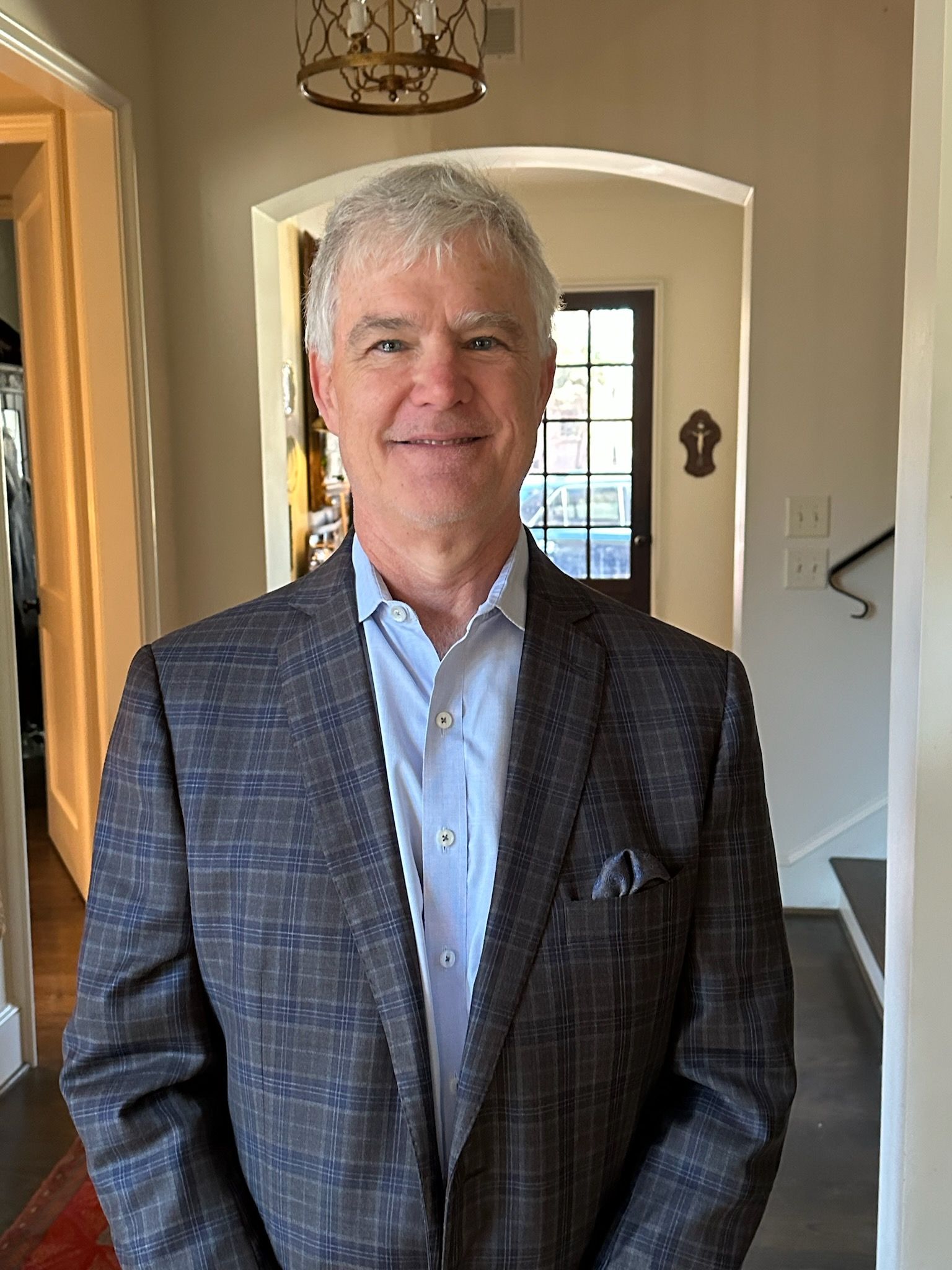 A man in a suit and tie is standing in a hallway.
