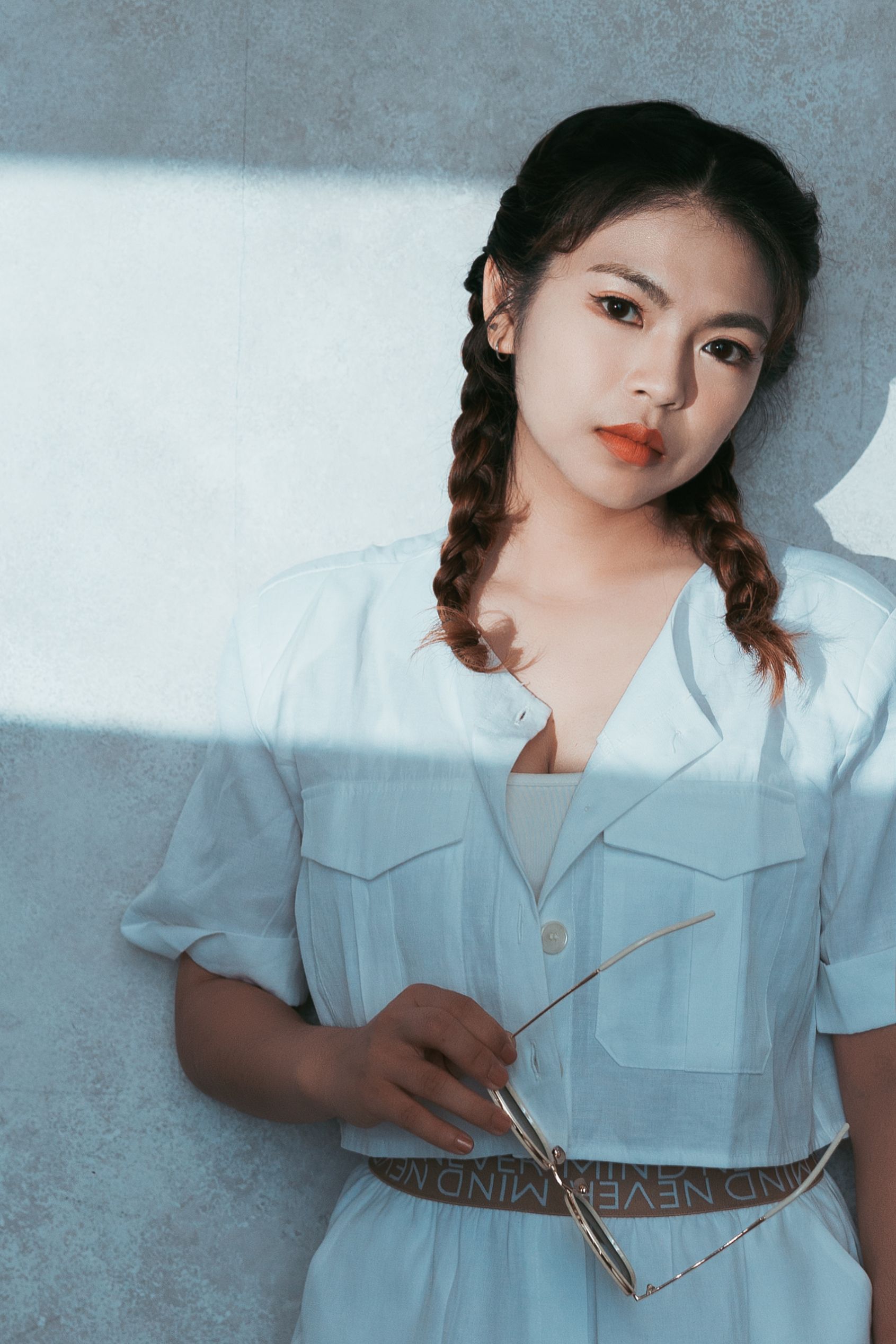 一個穿著白色洋裝的女人拿著一副眼鏡。