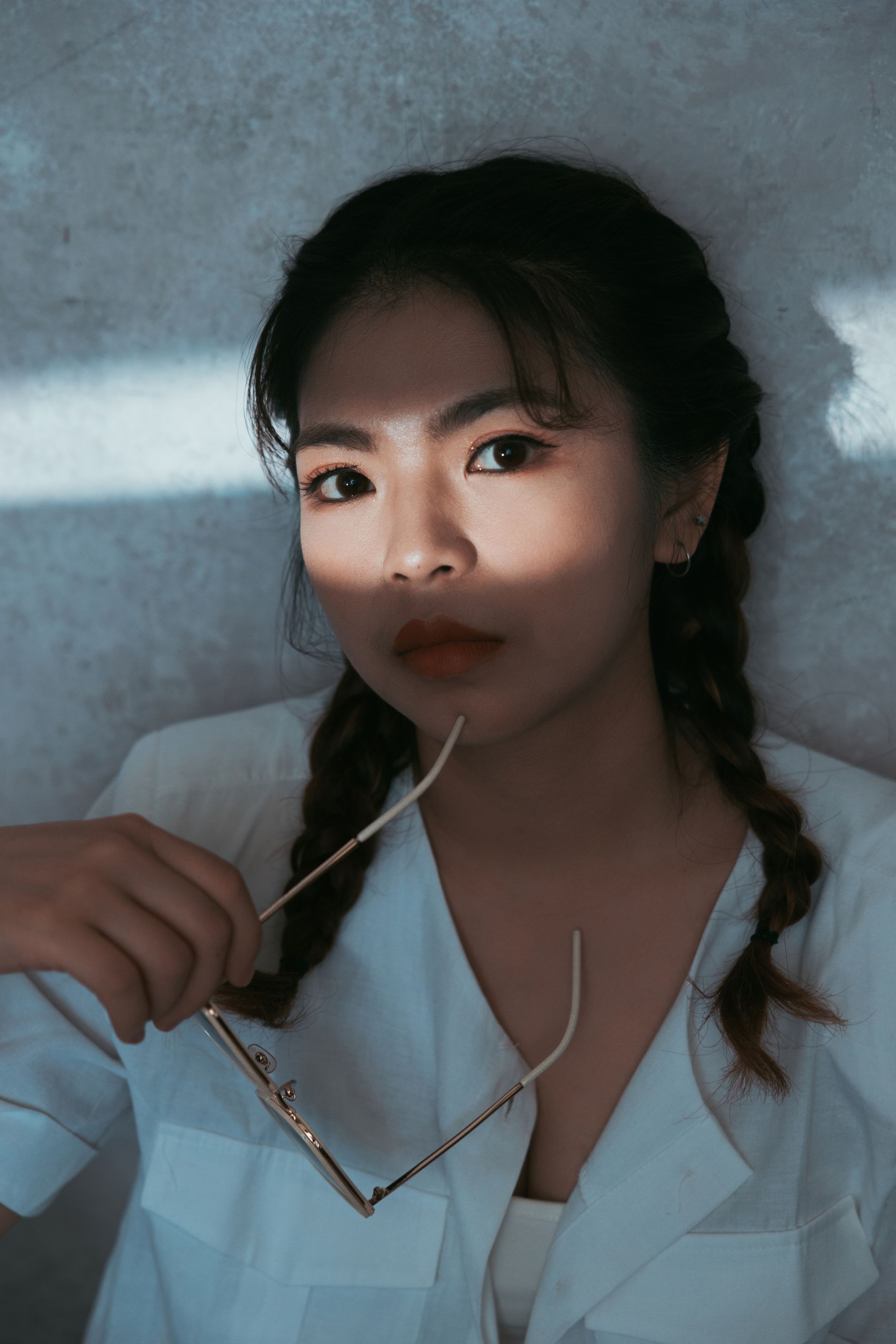 一個穿著白襯衫的女人手裡拿著一副眼鏡。