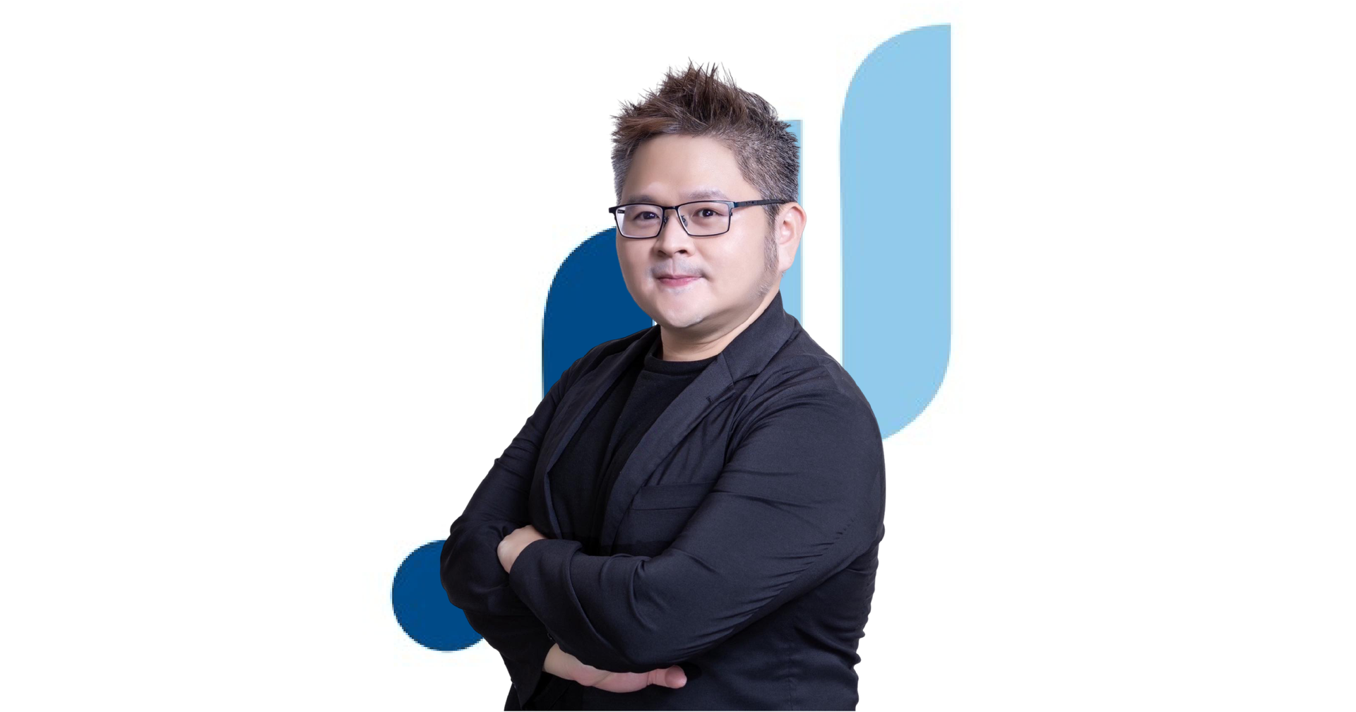 一個男人拿著麥克風站在大螢幕前。
