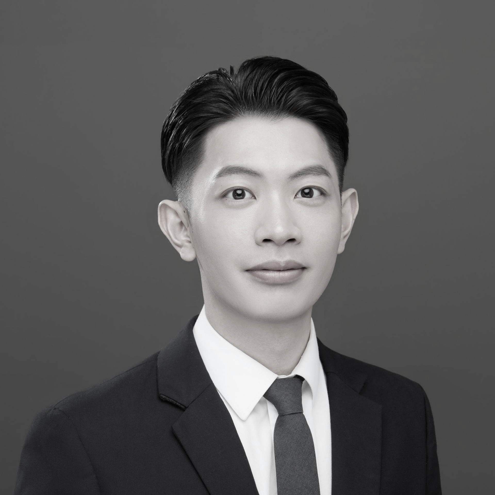 黑白照片中,一名身穿白色夾克的女子微笑著。