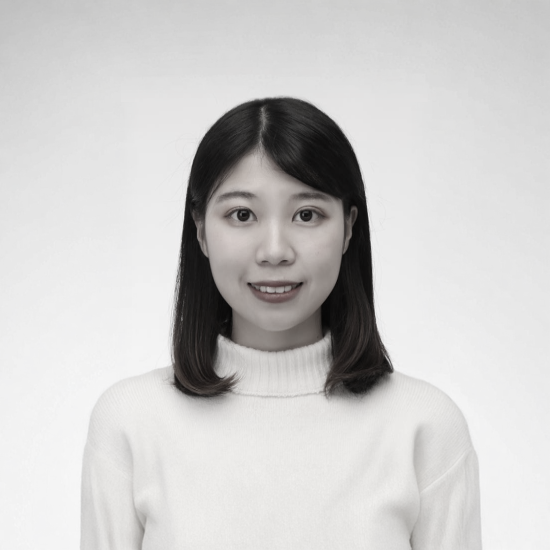一張黑白照片中,一位穿著西裝和白襯衫的女人微笑著。