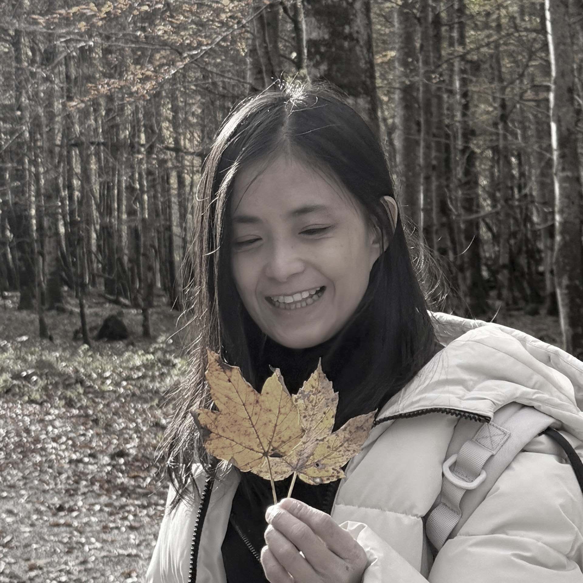 一張黑白照片,照片中一個穿著西裝的女人圍著一圈微笑。