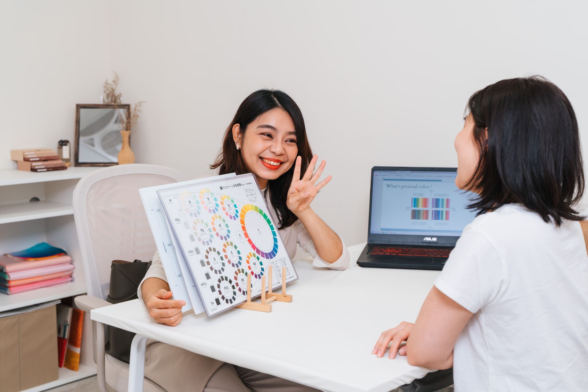 一個女人坐在桌旁與另一個女人交談。