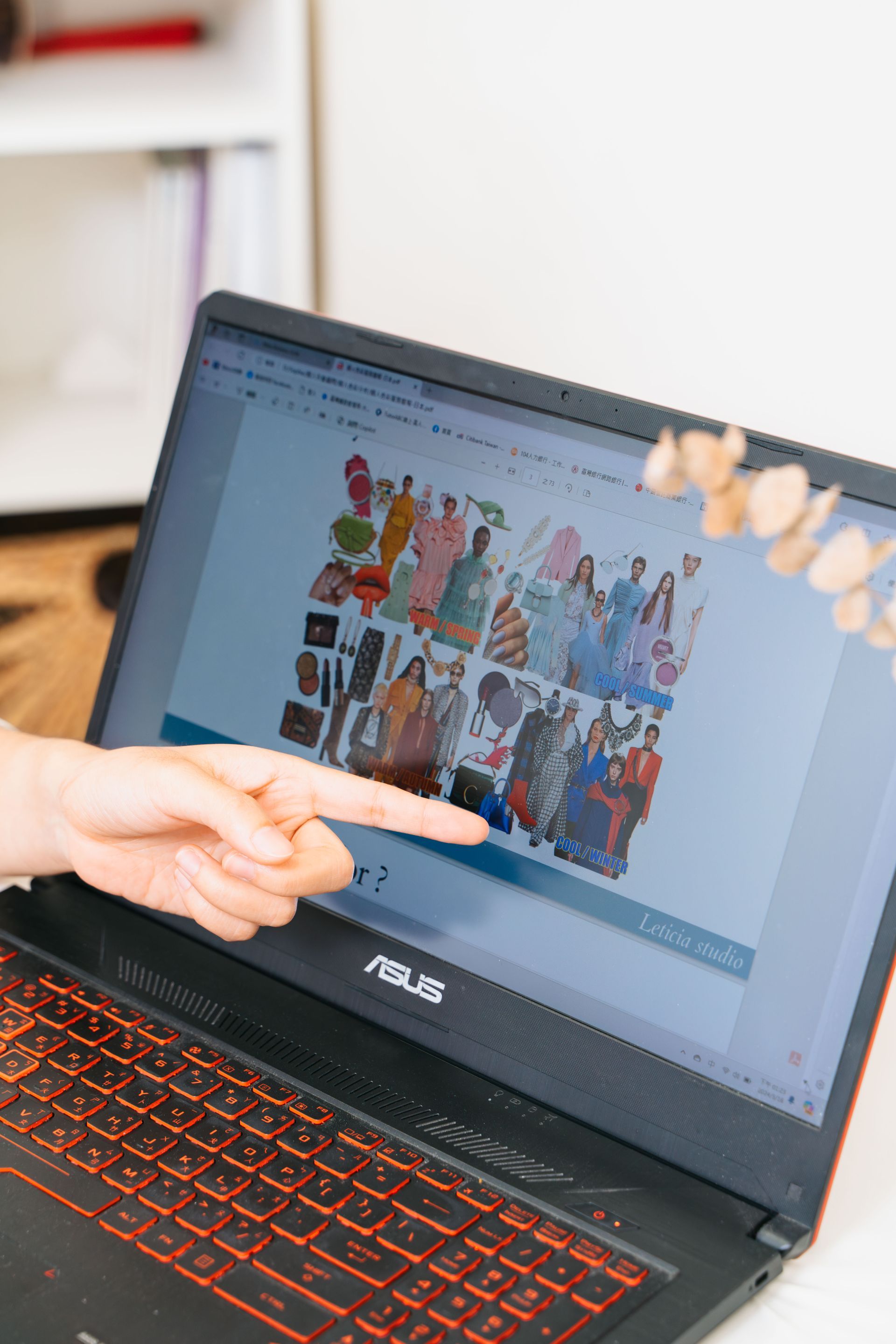 一個人指著筆記型電腦螢幕上的圖片。