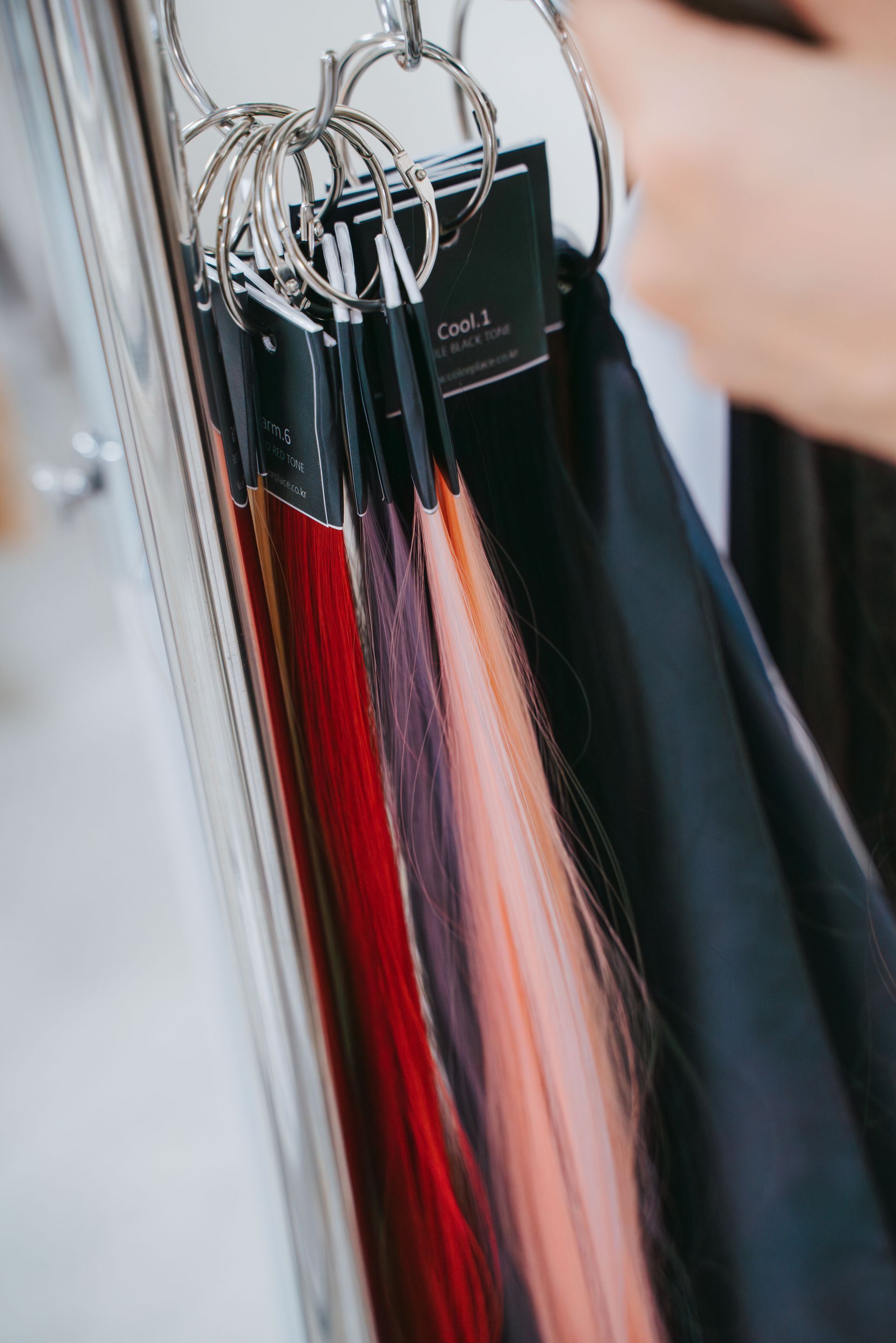 一個人拿著一束掛在架子上的接髮。