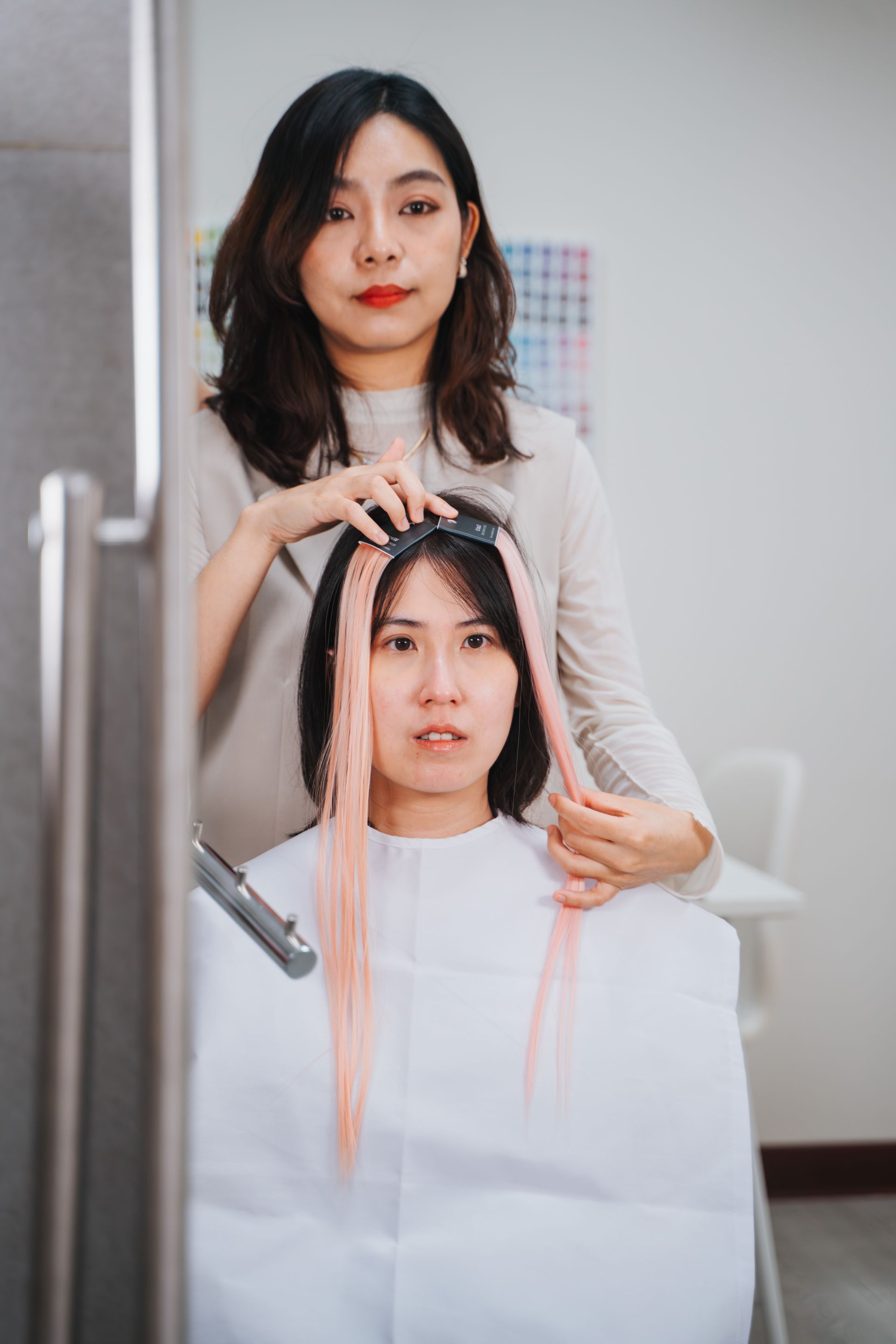 一個女人正在沙龍裡給另一個女人染頭髮。