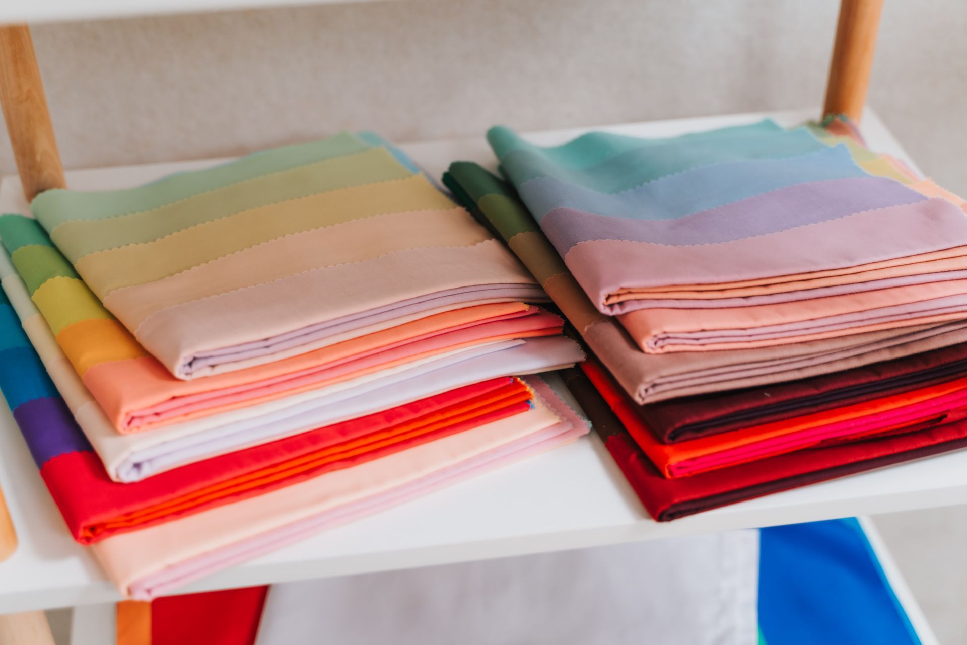 一個架子上擺滿了各種色彩繽紛的布料。