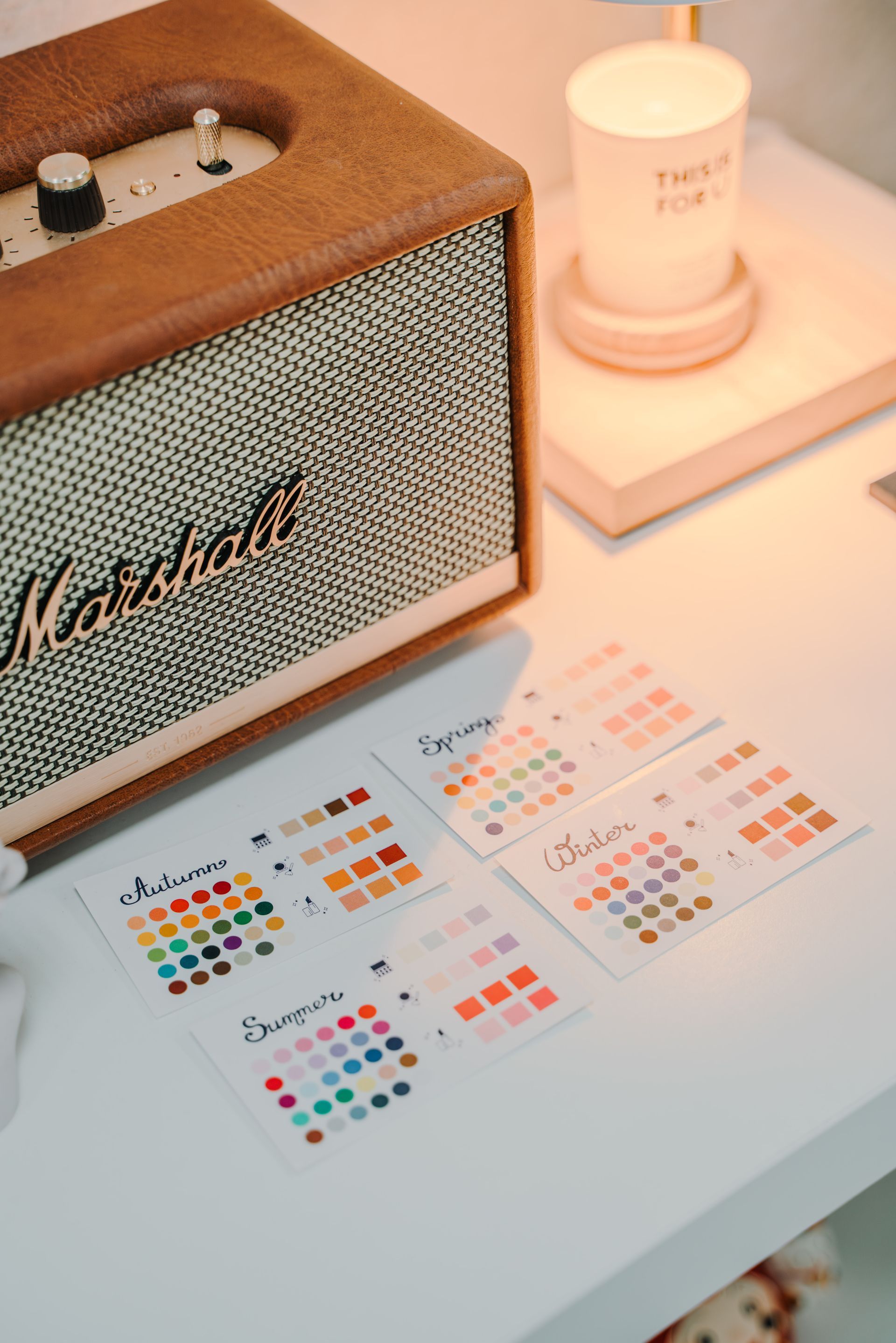 桌上有一台馬歇爾揚聲器，旁邊有一根蠟燭。