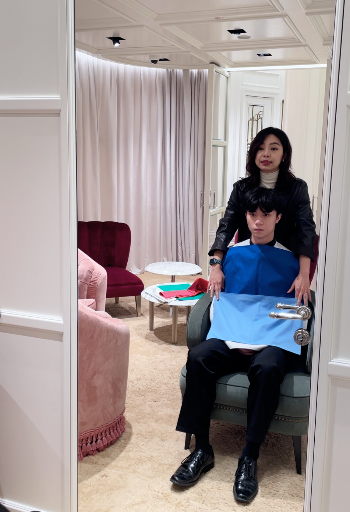 一個女人站在一個坐在椅子上的男人旁邊。