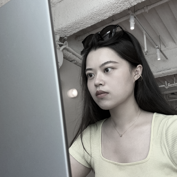 黑白照片中,一名身穿條紋襯衫的女子正在微笑。