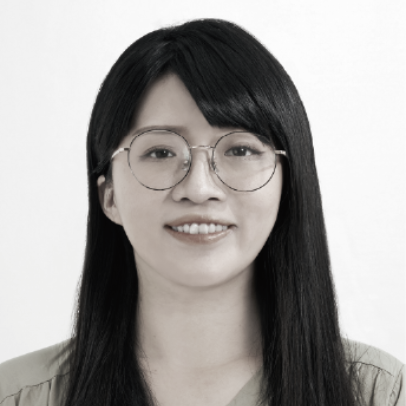 一張黑白照片中,一位穿著西裝和白襯衫的女人微笑著。