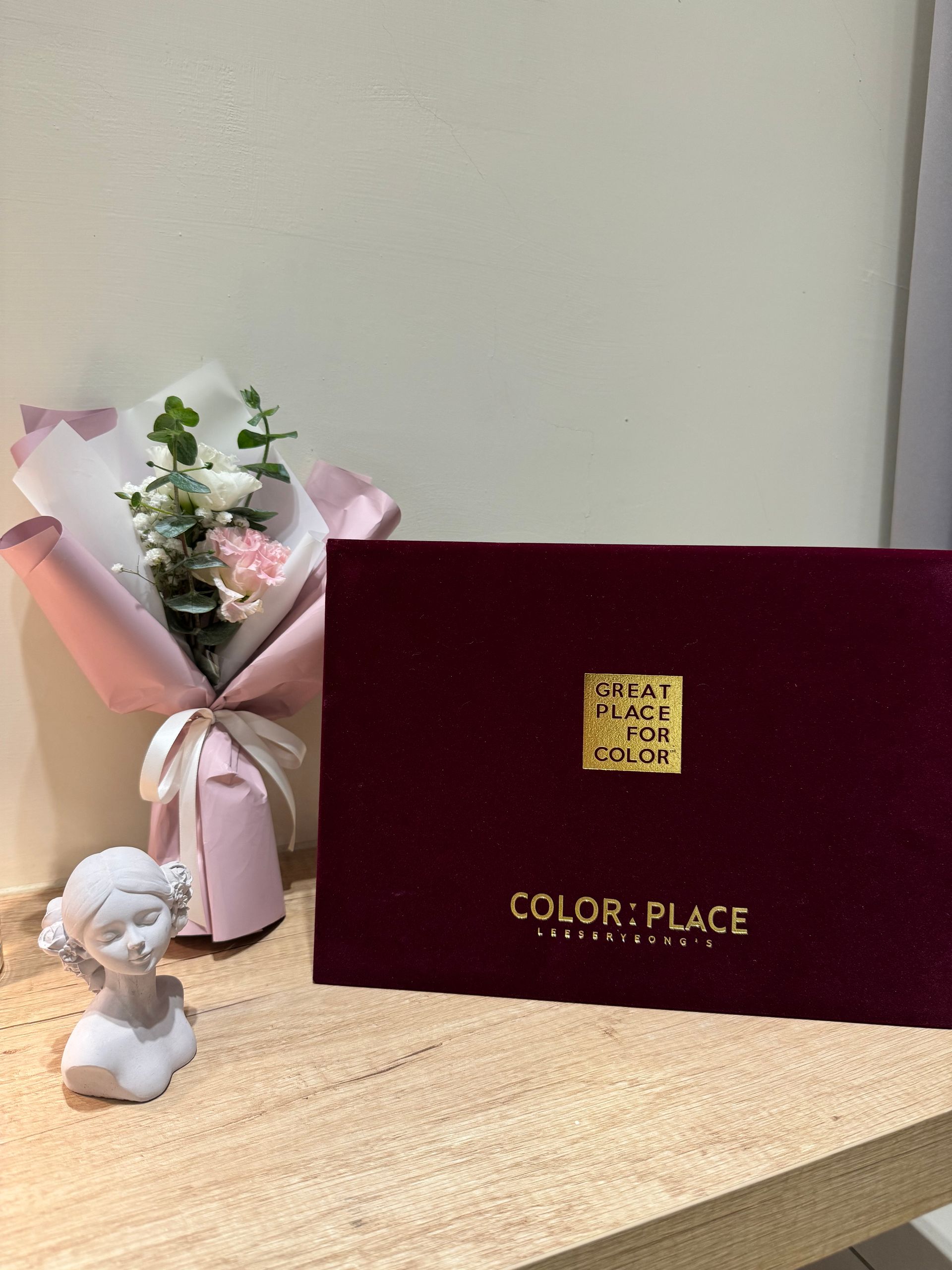 桌子上放著一束鮮花，旁邊是一張賀卡。