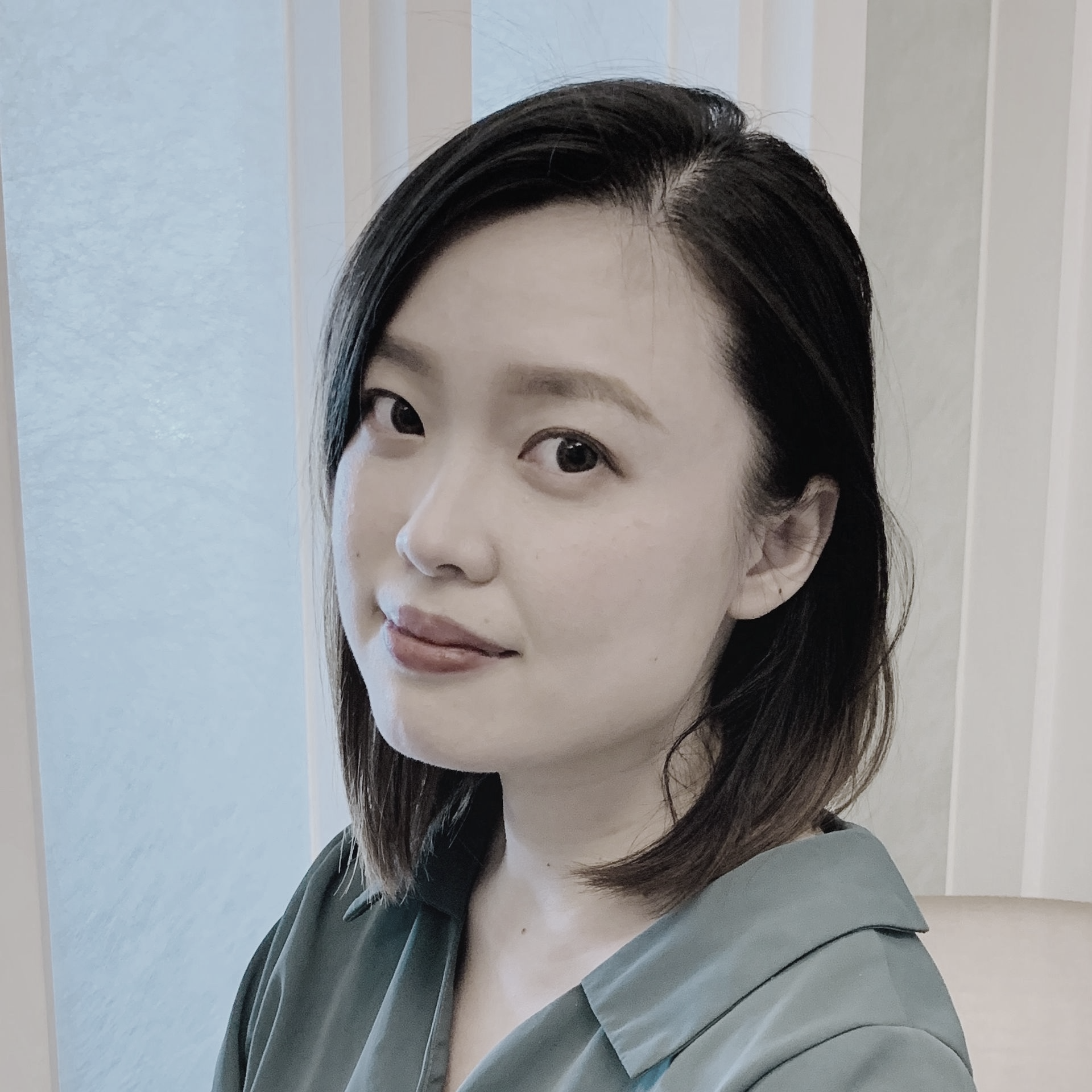 黑白照片中,一名身穿條紋襯衫的女子正在微笑。