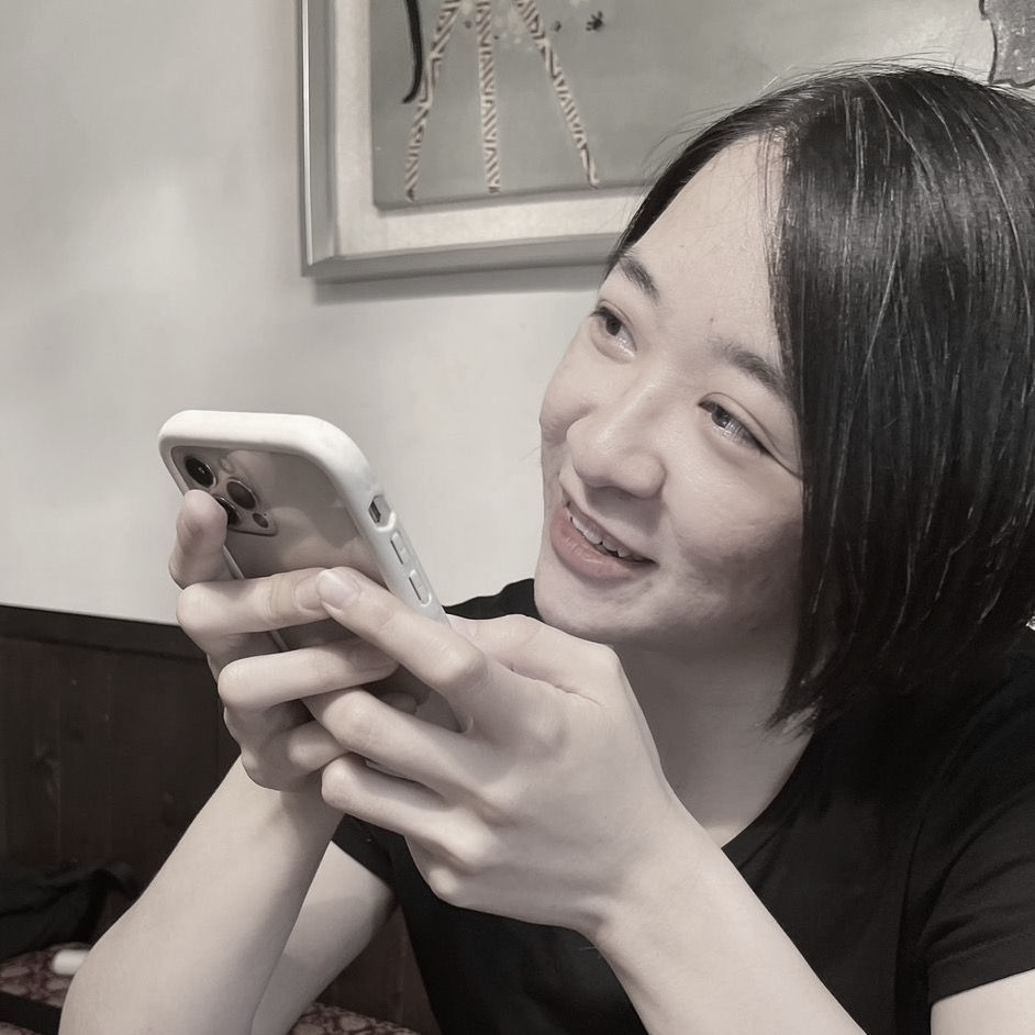 一張黑白照片中,一位穿著西裝和白襯衫的女人微笑著。