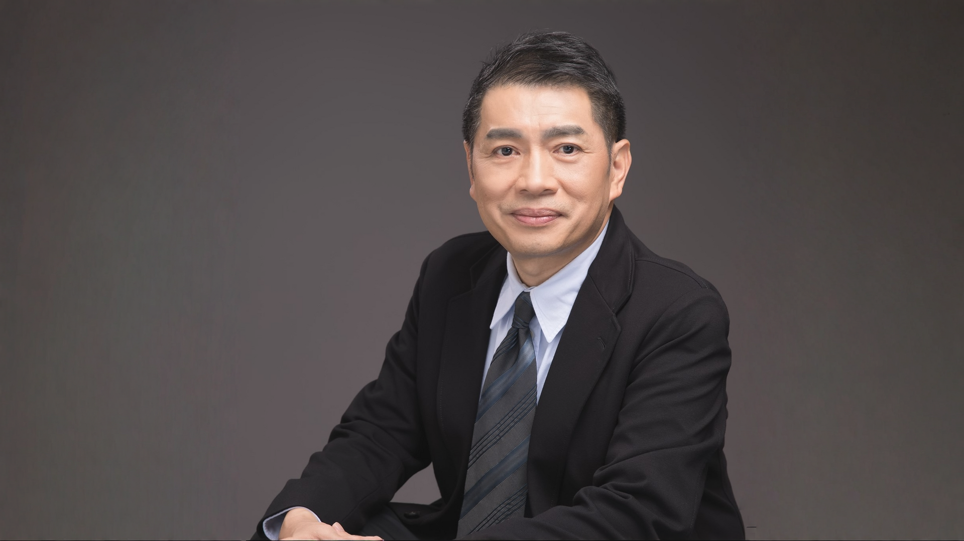 一個女人坐在桌邊,手裡拿著一杯咖啡。