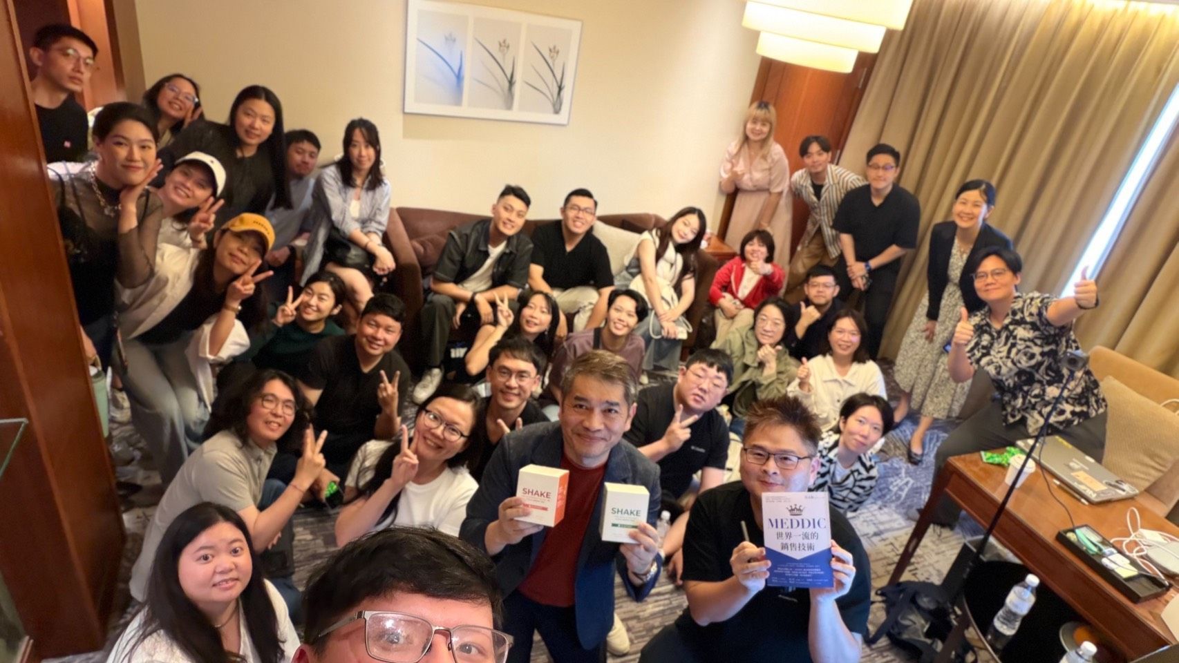 一群人坐在一張長桌旁，舉著牌子。