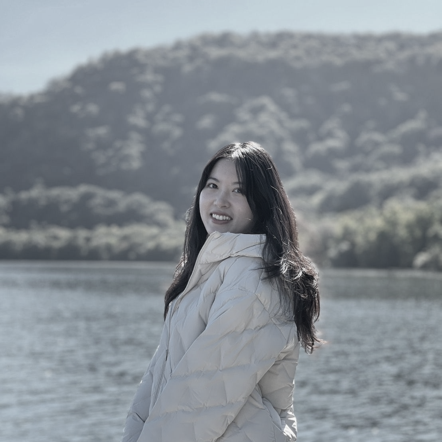 一張黑白照片,照片上是一位戴著掛繩、微笑的女人。