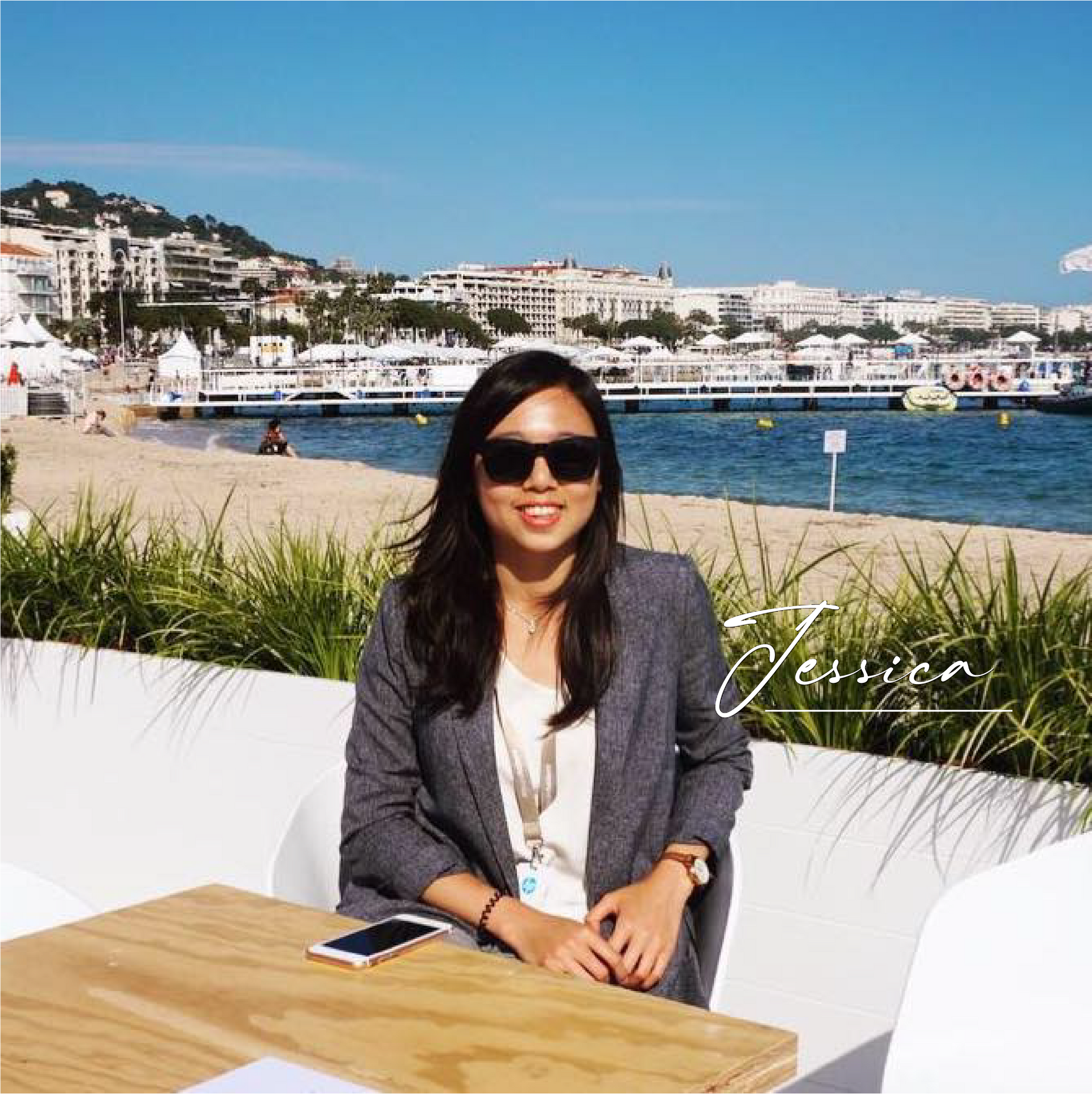 一位戴著墨鏡的女士坐在水體前的桌子旁