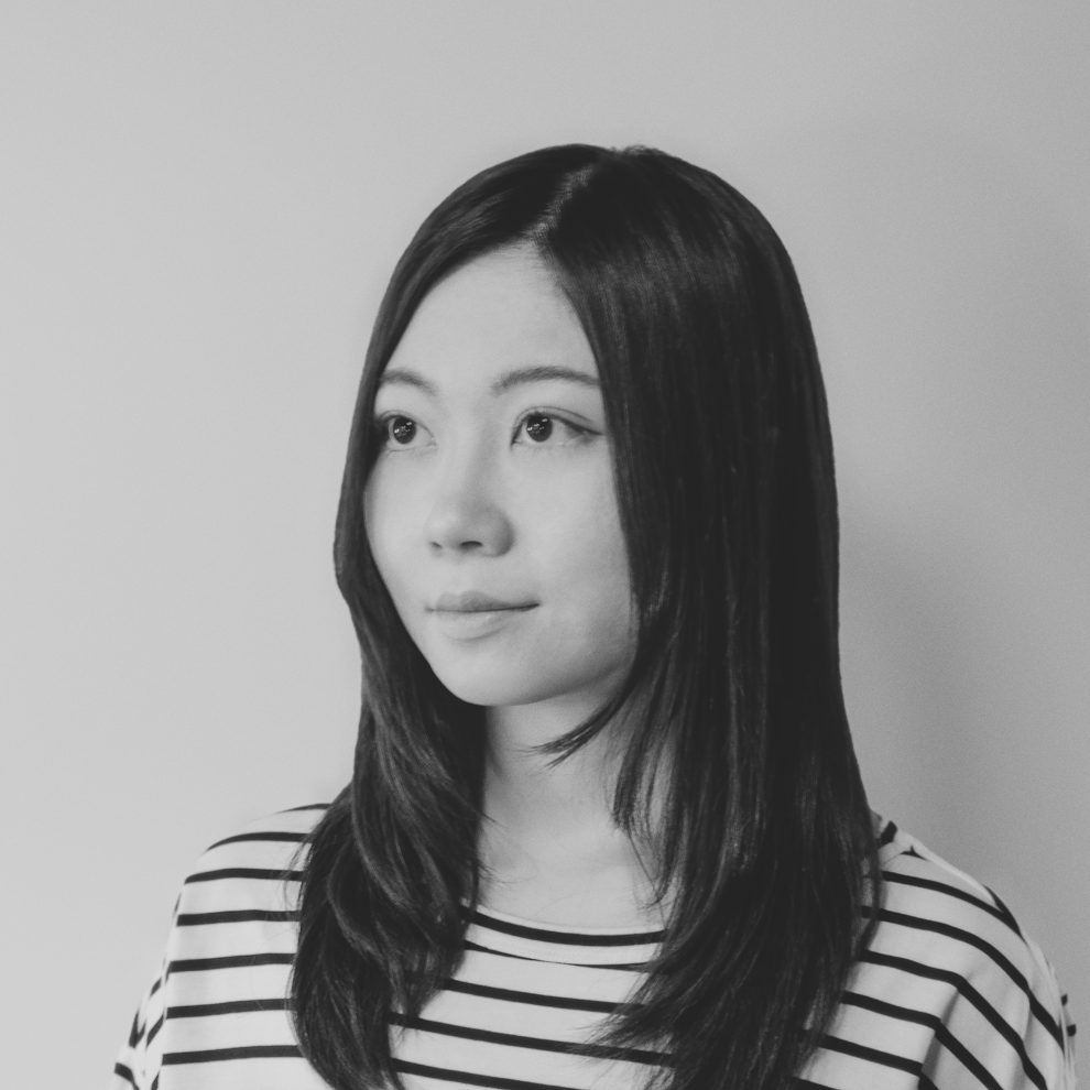 黑白照片中,一名身穿白色夾克的女子微笑著。