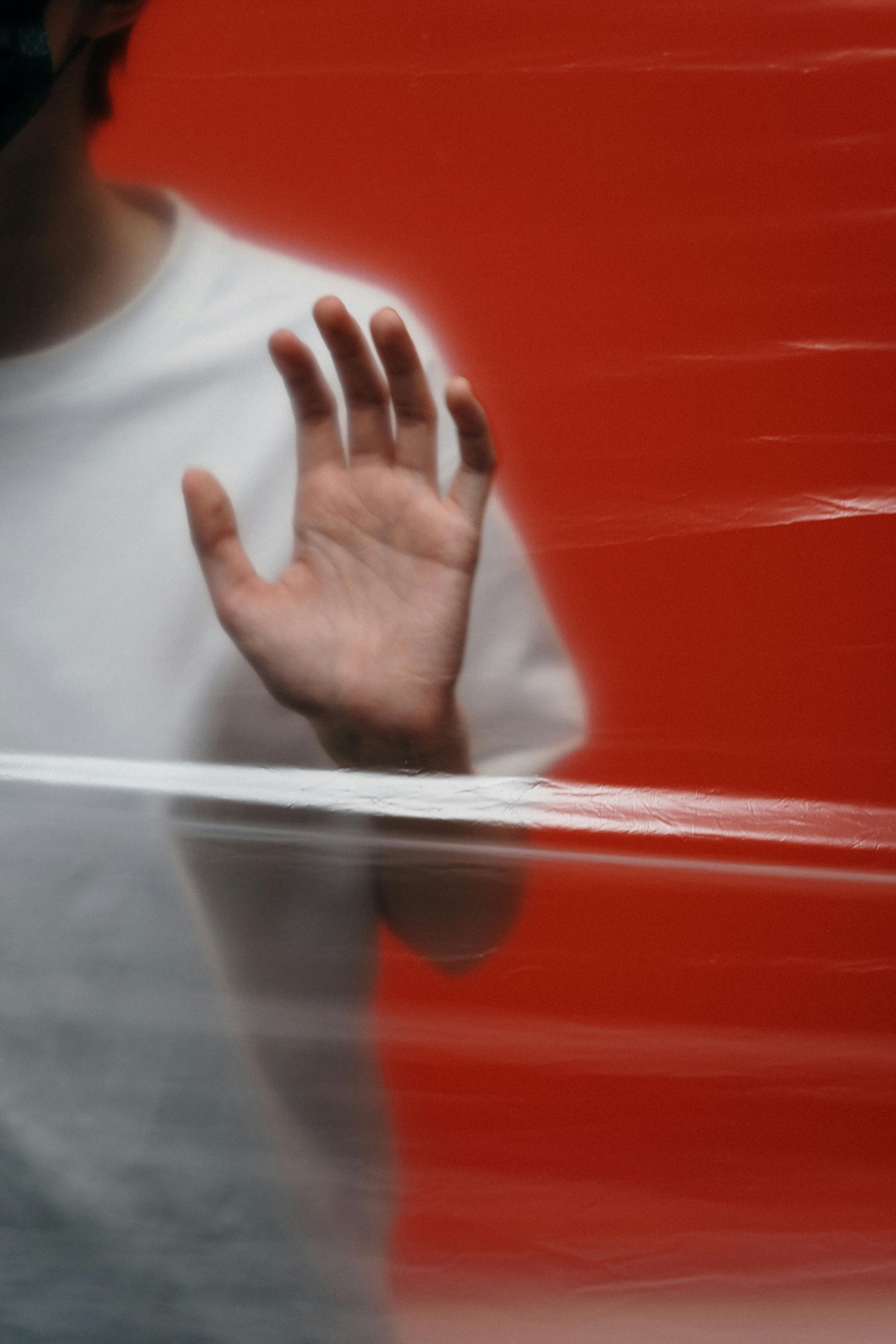 A person 's hand is visible behind a red wall