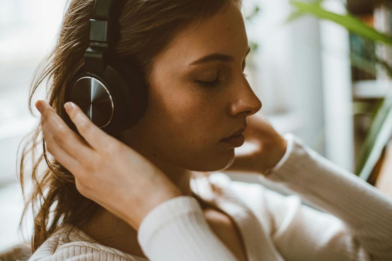 A woman is wearing headphones and listening to music.