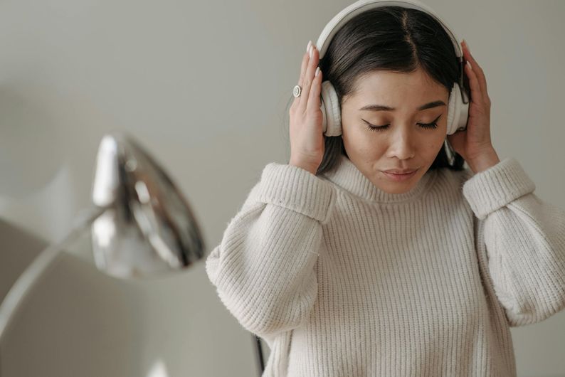A woman wearing headphones is listening to music.