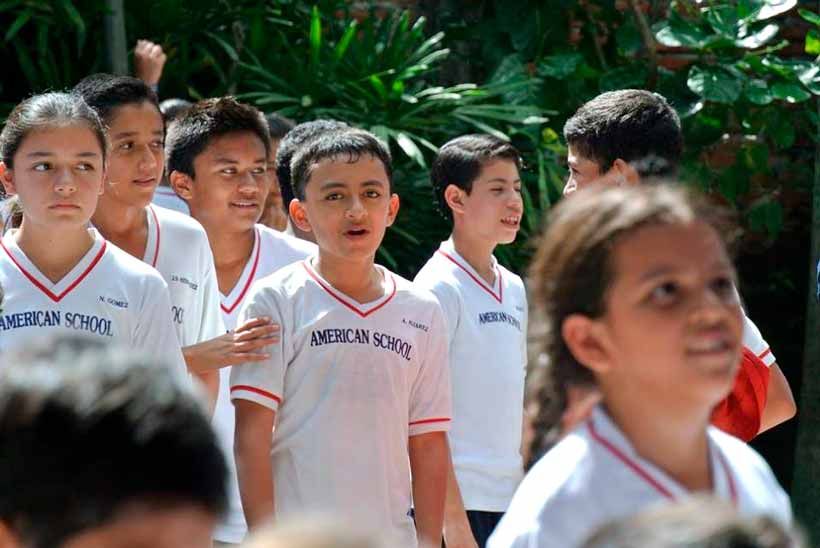 Un grupo de estudiantes con uniformes blancos idénticos con la inscripción 
