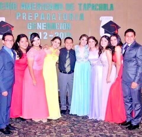 Un grupo de graduados posando con atuendo formal frente a una pancarta del Colegio Americano de Tapachula.