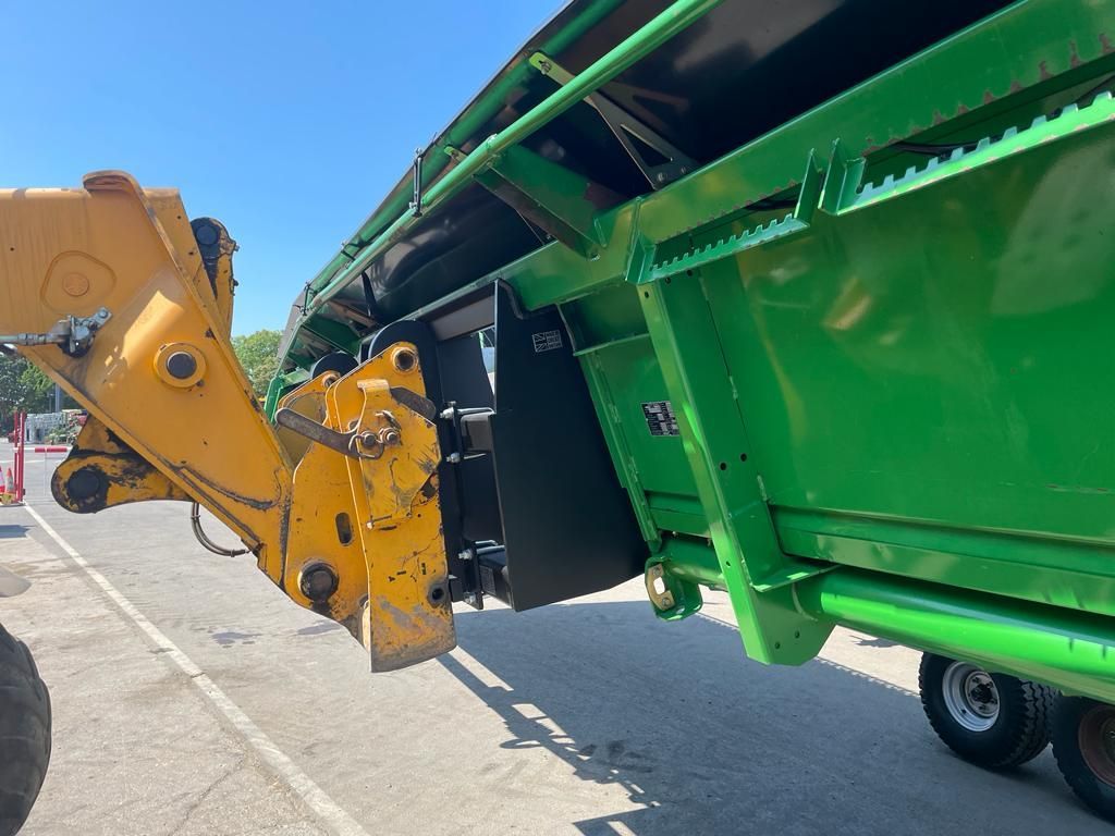 A green and yellow tractor is parked on the side of the road.